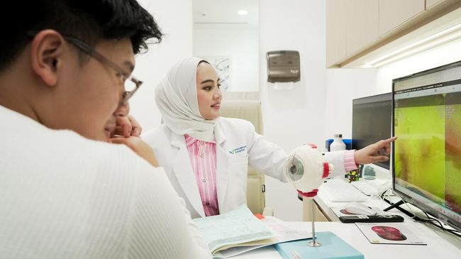 Seorang pasien sedang berkonsultasi dengan dokter