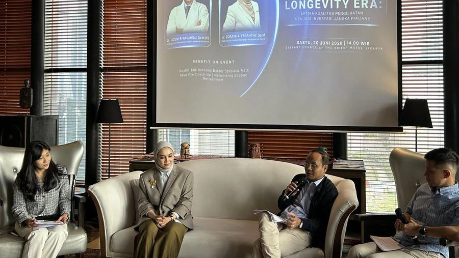Suasana acara bincang-bincang kesehatan mata bertajuk "Longevity Era" dengan empat orang pembicara duduk di sofa depan layar presentasi besar.